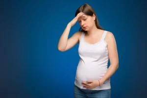 Pregnant woman with headache, suffering in perinatal time. Recommendation on which painkiller to use while you are expecting a baby. 