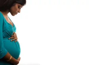 Pregnant woman eating healthy breakfast at home.