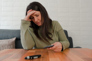 Hispanic Woman Holding Her Head Worried After Seeing Diabetes Test Result. 