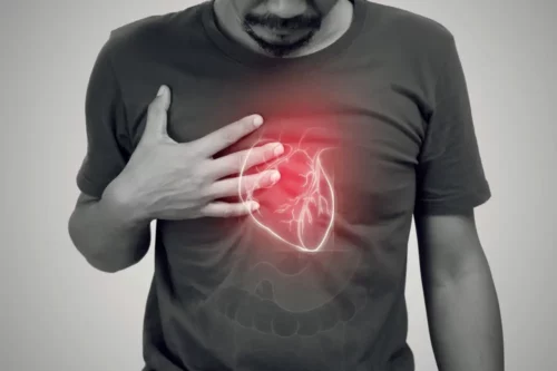Photograph of a man clutching his chest, suggesting a heart attack