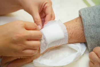 Close up old woman wrinkled skin hand, upper limb or arm to the wounded waiting for nurse treatment on wound dressing a bloody and brine of patient on white background.